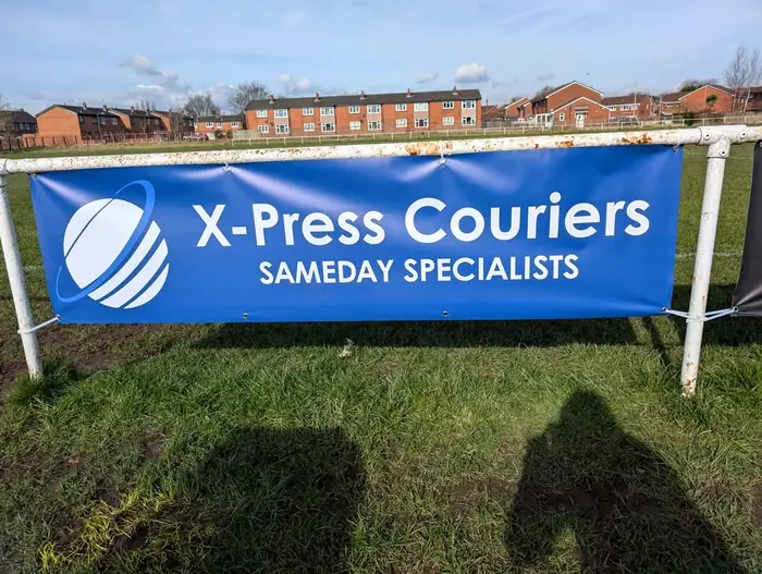 X-Press Couriers sponsor banner beside the first-team pitch at Newton